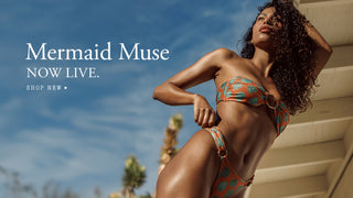 Woman in a colorful bikini standing against a blue sky with 'Mermaid Muse' text overlay.