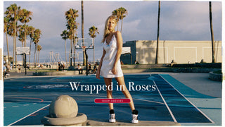 Model wearing a white mini dress with embroidered rose details. Shop dresses. 