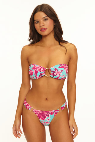 Woman wearing a colorful bikini with pink floral design on a white background
