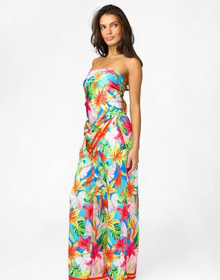 Woman wearing a colorful strapless dress with a floral pattern on a white background