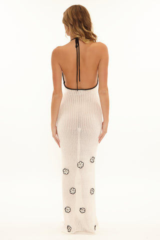 Woman wearing a white dress with black floral patterns on a white background