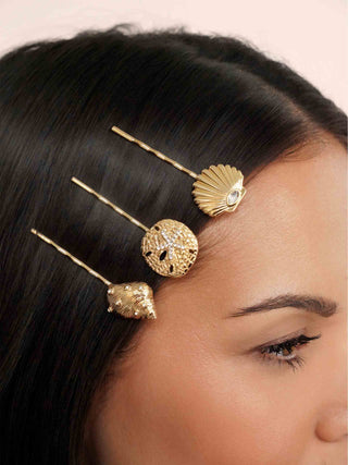 Close-up of a woman's hair with gold hairpins and decorative hairpiece.