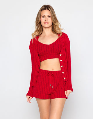 Woman wearing a red knit outfit with a cardigan on a white background