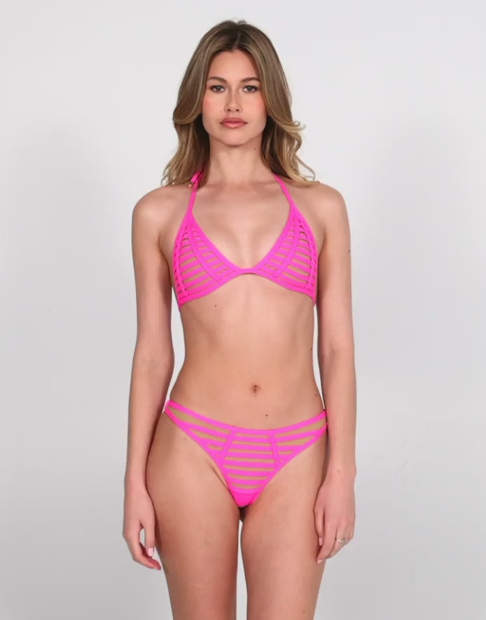 Model wearing the 'Hard Summer Tango Bottom - Shocking Pink,' a bold and edgy bikini bottom featuring vibrant hot pink mesh paneling with horizontal strap detailing. Designed for a cheeky fit and paired with the matching triangle top, this swim set delivers a head-turning festival-ready beach look.